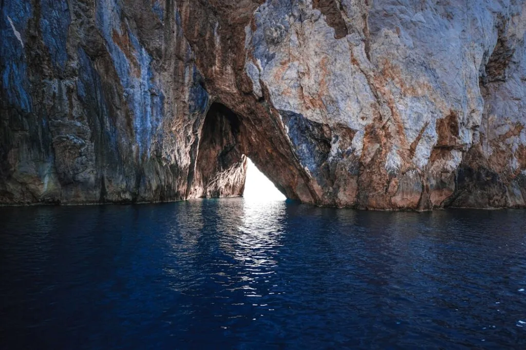 Sunlit triangular sea cave opening to deep blue Capri waters.