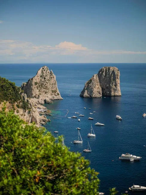 Boats anchored below the Faraglioni rocks off Capri's coastline.