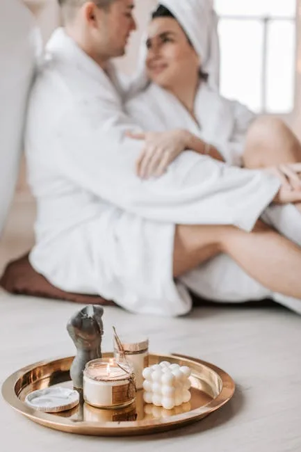 Couple in white robes blurred behind tray of candles and spa items