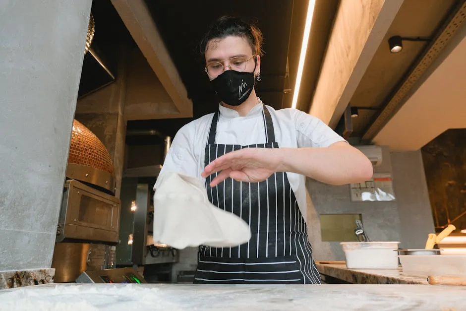 Pizzaiolo tossing dough in a Naples pizzeria by wood-fired oven