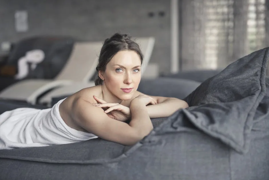 Woman wrapped in towel reclining on gray spa lounger in Naples