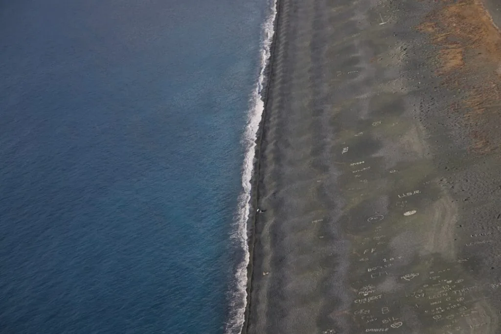 Aerial view of black sand beach on Ischia with small waves