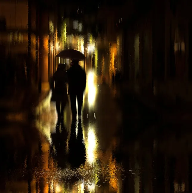 Silhouetted couple sharing an umbrella on a rainy illuminated street