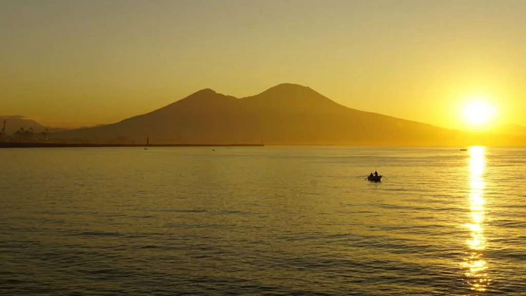 Sunset over Bay of Naples with Mount Vesuvius silhouette and boat