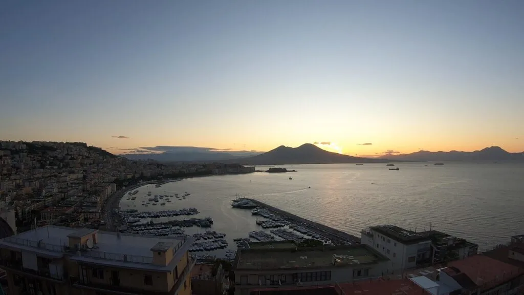 Panoramablick auf Neapels Bucht mit Hafen und Vesuv im Sonnenuntergang