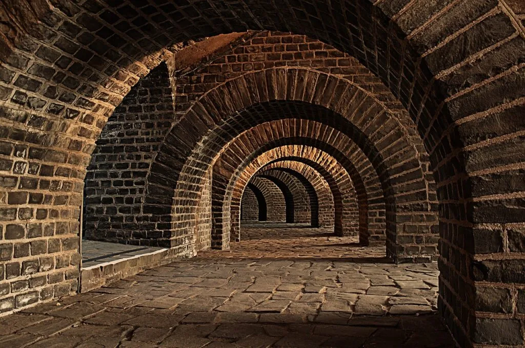 Series of brick vaulted arches forming a corridor in Naples catacombs