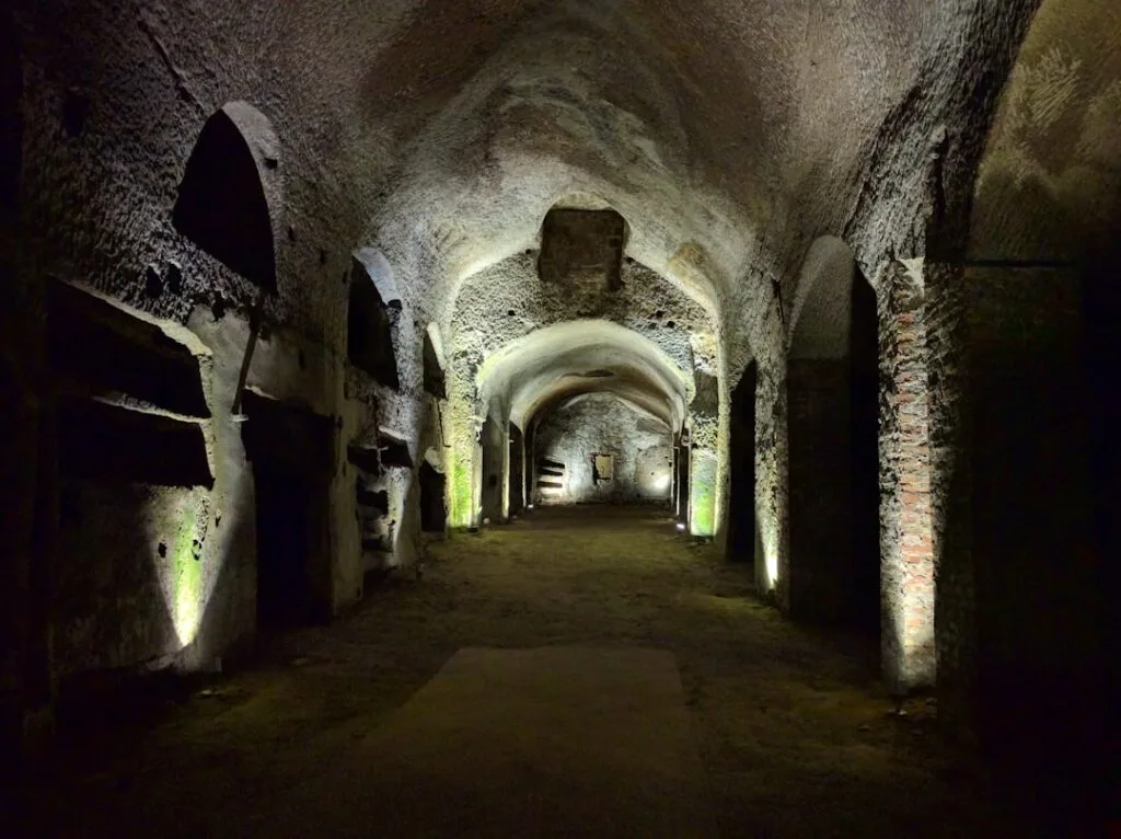 Spacious vaulted burial chamber with carved niches in San Gennaro Catacombs, Naples