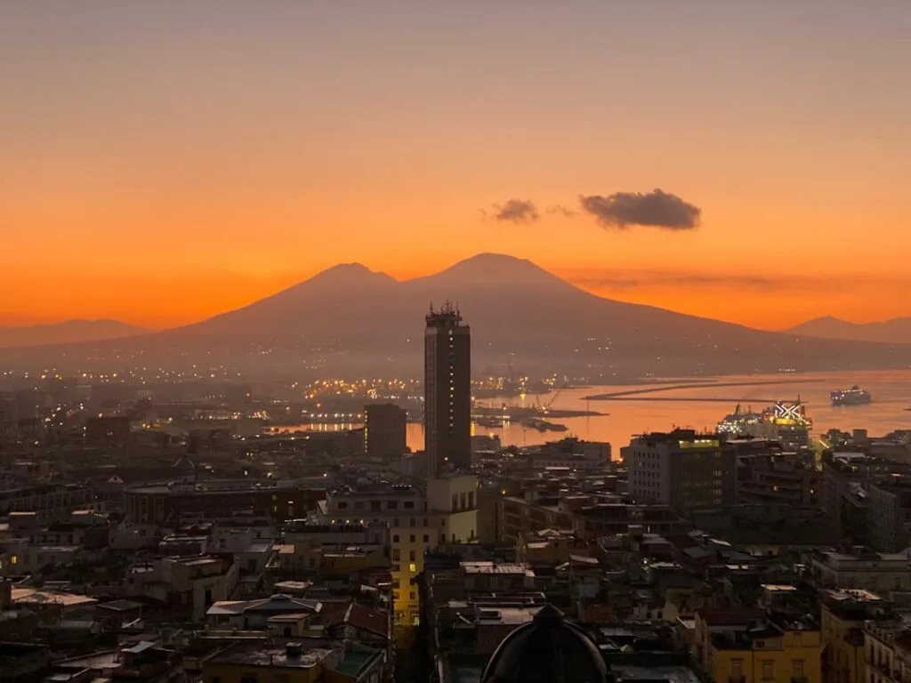 Naples skyline and port at sunset with Mount Vesuvius silhouette