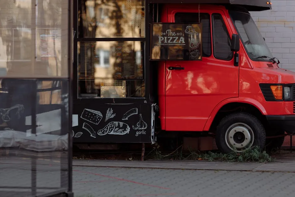 Red pizza truck with garlic illustrations parked on a Naples street