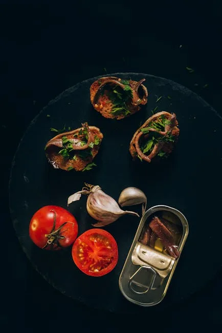 Vorspeisen mit Tomate, Knoblauch und Sardellen auf dunklem Teller