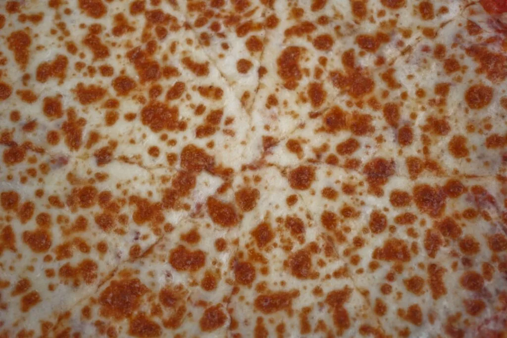 Close-up of bubbly browned pizza cheese, typical Naples style