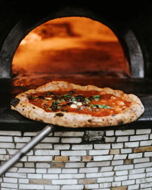 Wood-fired oven with pizza on a peel baking in Naples kitchen