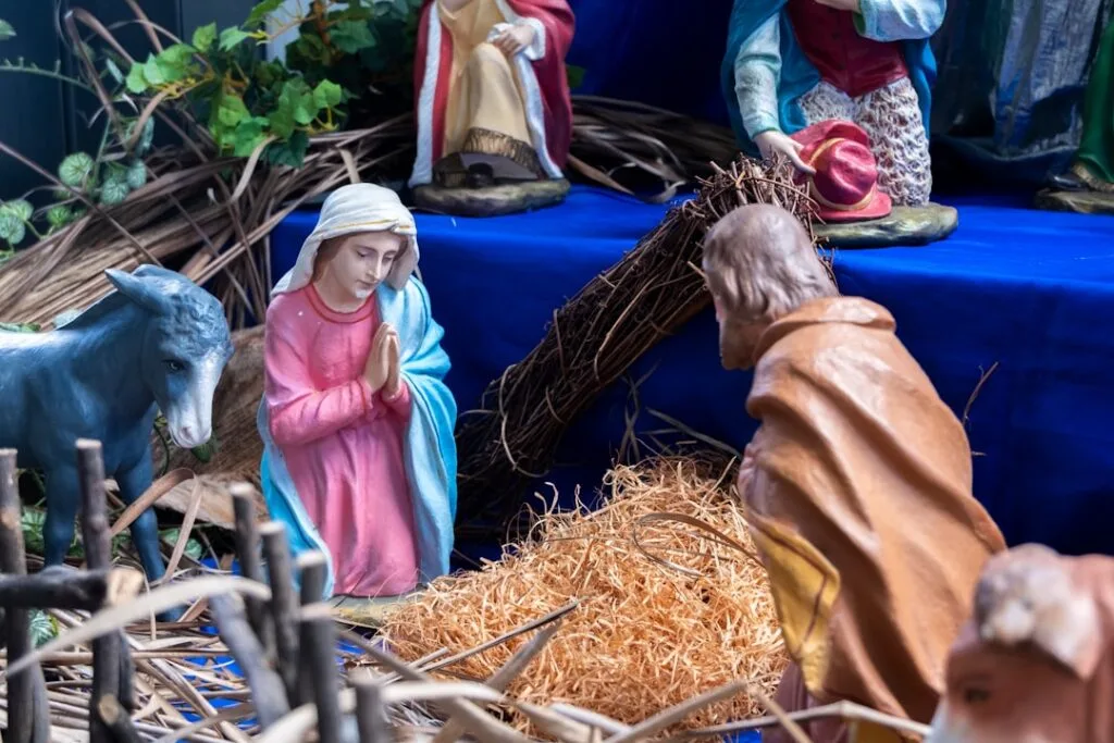 Krippenszene mit bemalten Figuren, Heu und Esel in Neapel