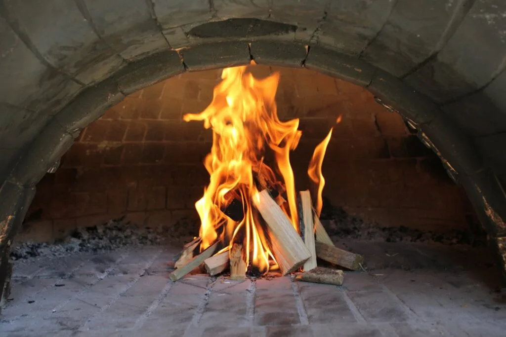Wood fire burning inside a traditional pizza oven in Naples