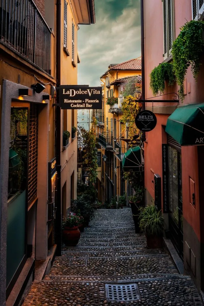 Whitewashed cobblestone alley with pink bougainvillea in Capri