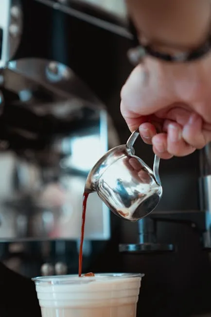 Barista pouring espresso shot into a milk cup at a Naples café