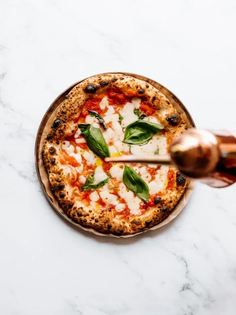 Neapolitan margherita pizza with basil being drizzled with oil