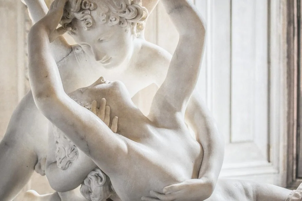 Close-up of white marble sculpture depicting two embracing figures
