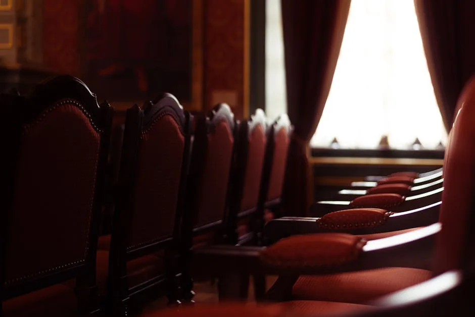 Red velvet chairs in an elegant Naples concert hall near window