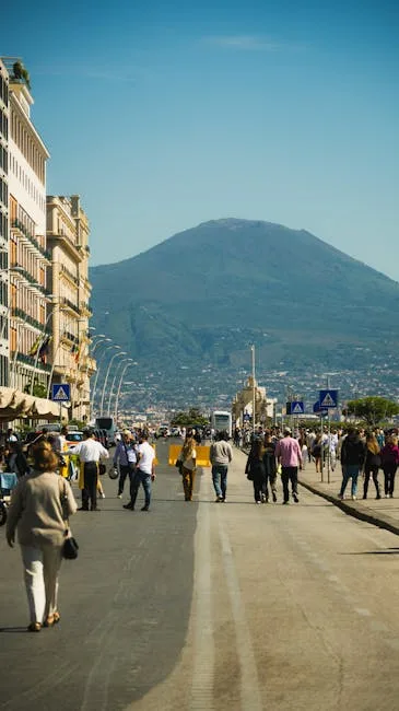 Naples waterfront promenade with people walking and Mount Vesuvius looming