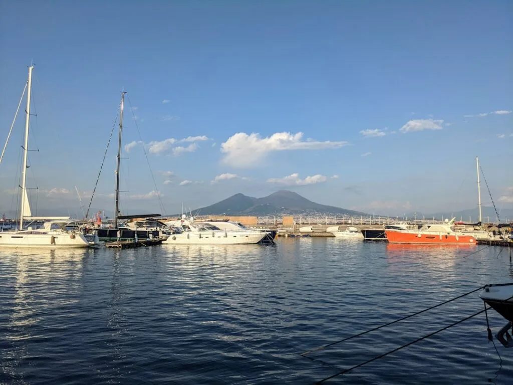 Segel- und Motorboote im Hafen, Vesuv vor Neapel deutlich sichtbar.