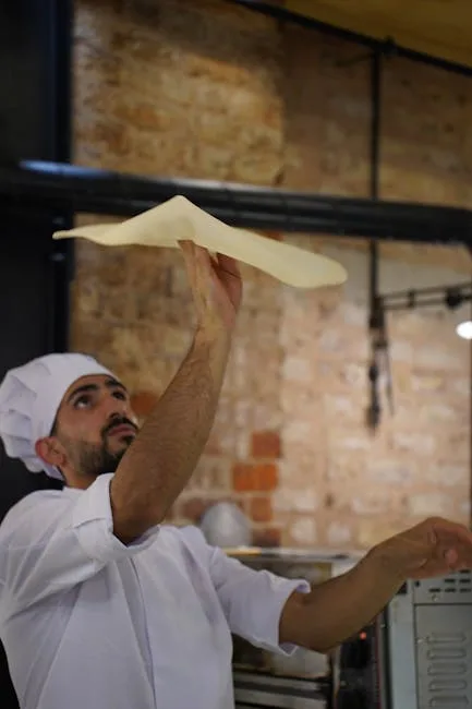Pizzaiolo tossing stretched pizza dough by hand in Naples kitchen