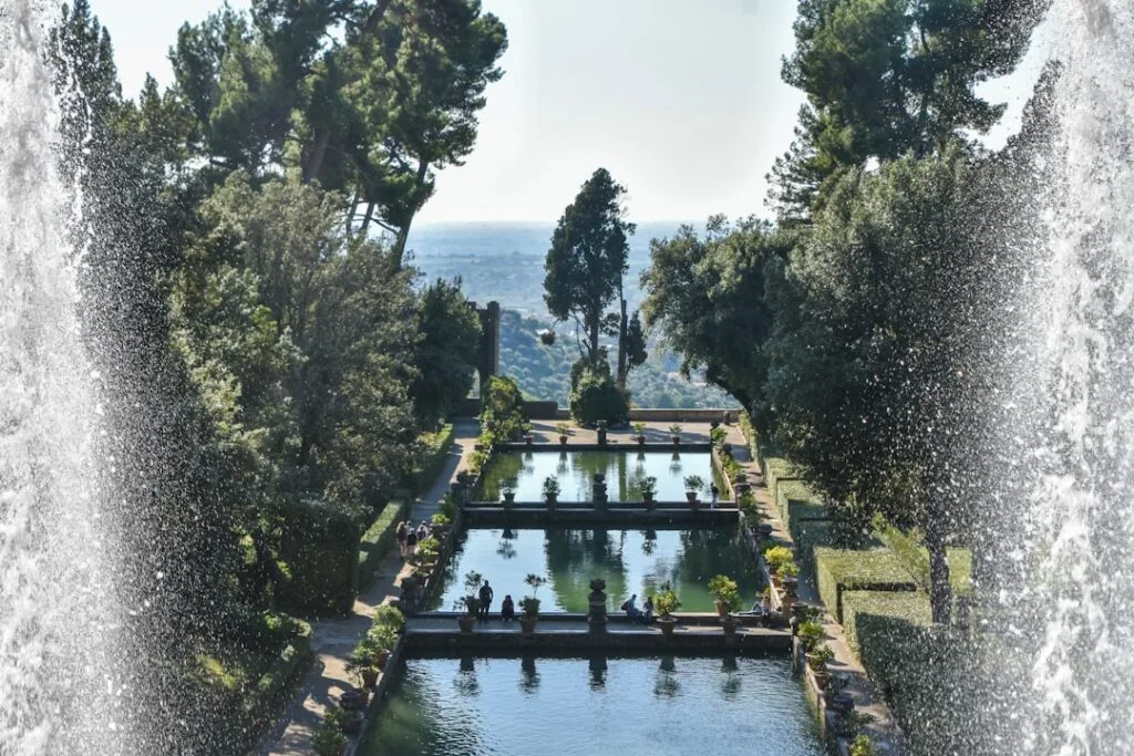 Terraced reflecting pools viewed through fountain spray in Ischia gardens